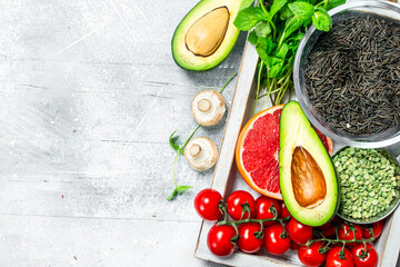 Healthy food. Different organic fruits and vegetables with black rice in wooden box.