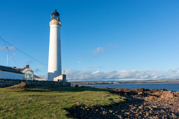 Fototapeta na wymiar Lighthouse on the coast of the North Sea in Scotland against a dramatic sky