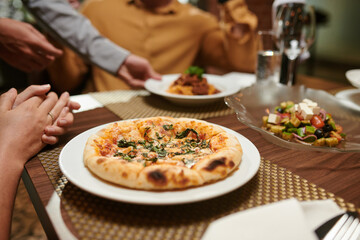 Plate with hot delicious pizza on table in fancy restaurant