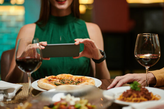 Woman photographing her food before eating to post on social media