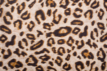 Fabric with an applied image of the skin of a wild animal cheetah or leopard, close-up. Leopard skin imitation, close up