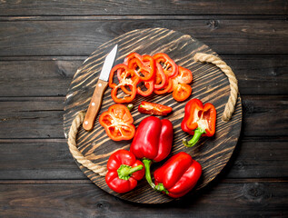 Cut and whole fresh sweet pepper on tray with knife.