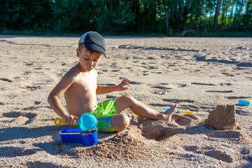 little boy on the beach playing in the sand