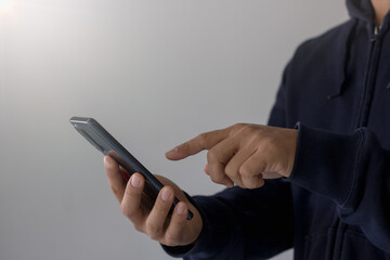 Close-up of a man's handman hand holding smart phone on white background with copy space.