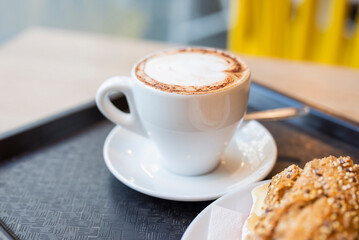 cappuccino coffee with foam in a restaurant in a white cup for breakfast