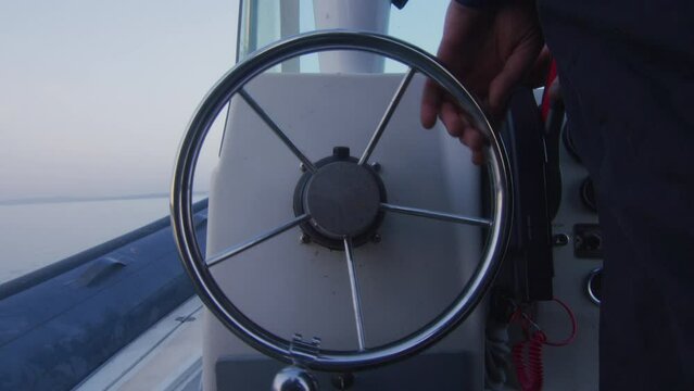 A sailor turns the wheel to navigate his boat on Lake Geneva, Switzerland