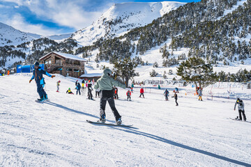 Instructor or trainer teaching how to snowboard in El Tarter green area. Winter ski holidays in...