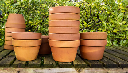 Stacks of various terracotta pots for plants for sale at a garden store.