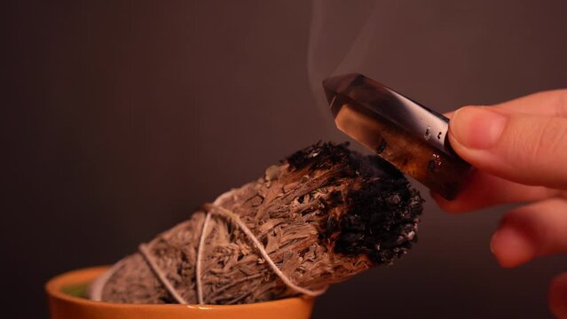 Cleansing smoky quartz crystal point with white sage smoke