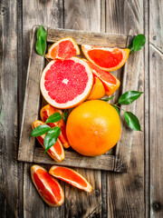 Ripe grapefruit on a wooden tray.