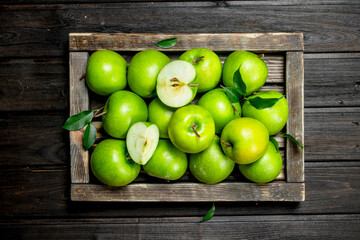 Juicy green apples and Apple slices in a wooden box.