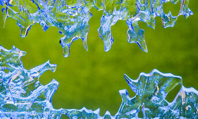 frozen water drops on a green background.blue ice patterns of unusual natural shape.beautiful...