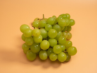 Green grapes. Ripe grapes on an orange background.
