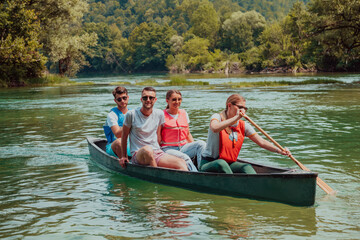 Fototapeta na wymiar Group adventurous explorer friends are canoeing in a wild river