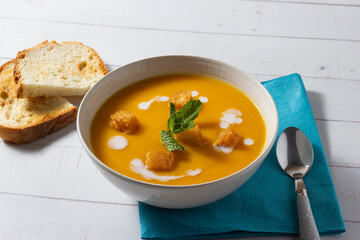 Pumpkin cream soup garnished with toasted bread, sour cream, mint and pepper.  Vegetarian, health food, diet, recipe or menu concept.