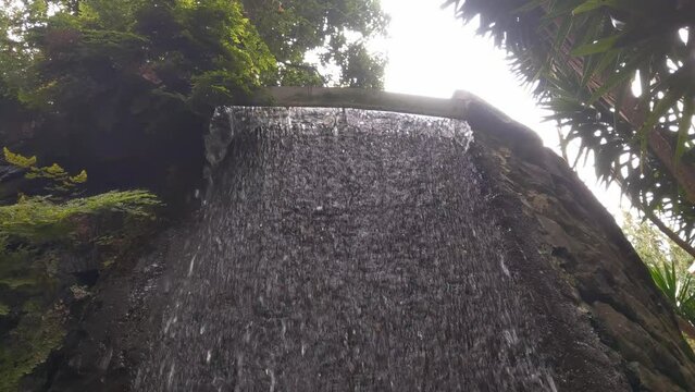 A stream of cold clear water flows from a height. A small waterfall.
