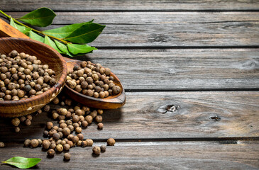 Black pepper peas in bowl with spoon and Bay leaves.