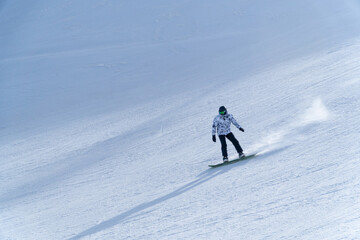 man snowboarding on the mountain on a sunny day
