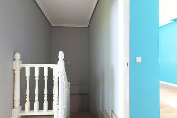 Wooden staircase with white balustrade and pink granite steps in a multi-storey detached house