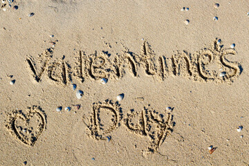 Happy Valentine's Day written on the sand of tropical beach
