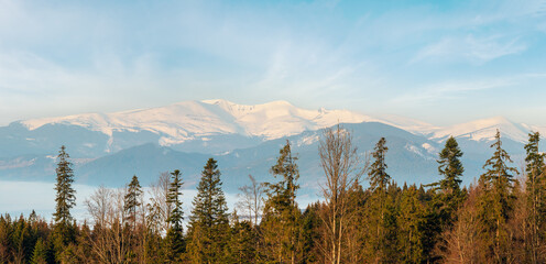 Early morning spring Carpathian mountains plateau landscape with snow-covered ridge tops in far, Ukraine.
