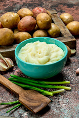 Mashed potatoes in a bowl with green onions .