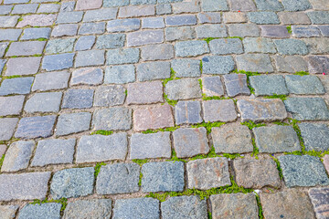 Granite dirty paving stones in the city. Road from paving stones for background and texture. The old road of granite paving stones