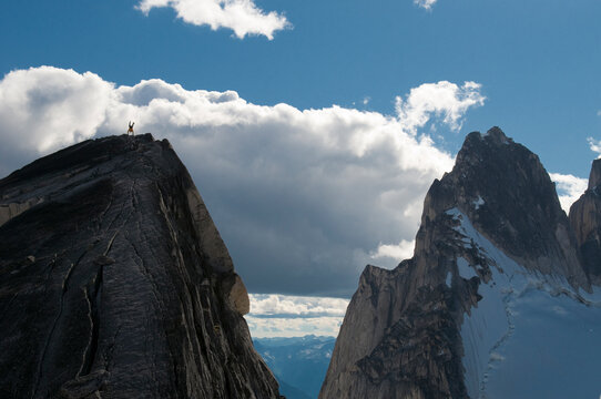 Tiny man doing a handstand on summit, Bugaboo Provincial Park, Radium, British Columbia, Canada.
