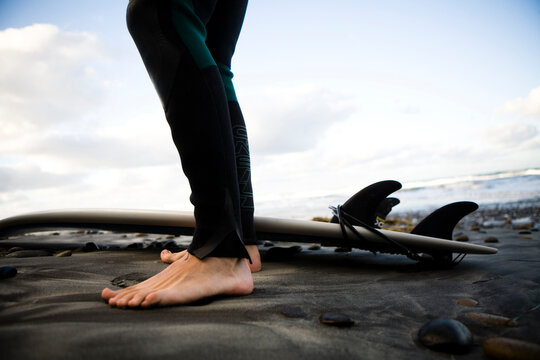 Surfers feet and surfboard in San Diego, CA.