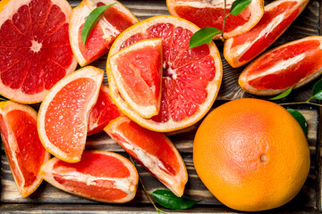 Ripe grapefruit on a wooden tray.
