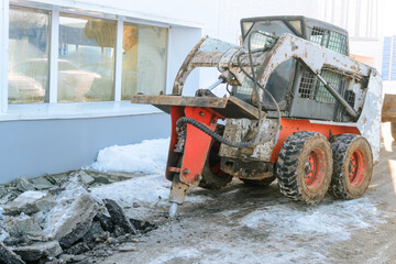 Hydraulic jack hammer on a skid steer loader breaker. Hydraulic attachments for the destruction of asphalt, concrete, loosening of frozen soil.