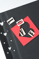 Obraz premium letters and heart frame on grungy and torn photo album paper