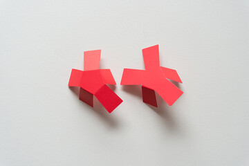 two red paper asterisks folded on blank paper