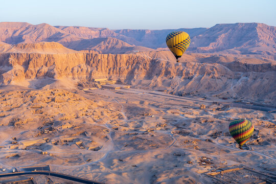 Two hot air balloon at sunrise in front of Temple of Hatshepsut near the Valley of the Kings in Luxor, Egypt