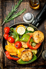 Assortment of grilled vegetables with a pan of herbs and spices on a cutting Board.