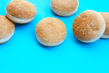 Hamburger buns with sesame on blue background.