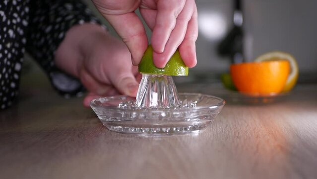 Squeeze lime juice close up with a glass squeezer