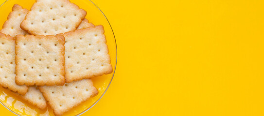 Dry cracker cookies on yellow background.