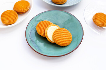 Custard cream sandwich biscuits on white background.
