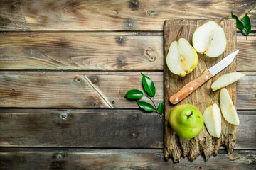 Pieces of pear on the cutting Board with a knife.