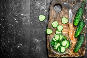 Obraz na płótnie Canvas Sliced cucumbers on a cutting Board with a knife.