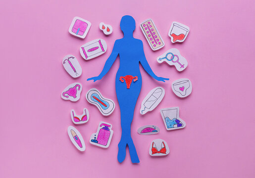 Woman`s health. Paper female figure and different stickers on pale pink background, flat lay