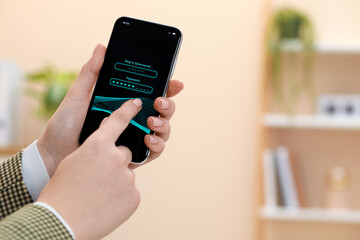 Woman unlocking smartphone with blocked screen indoors, closeup. Space for text