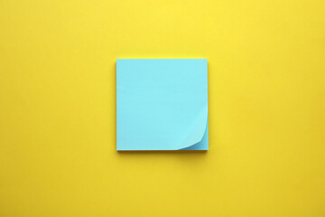 Paper note on yellow background, top view