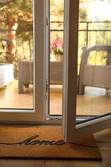 Doormat with word Home on parquet floor indoors