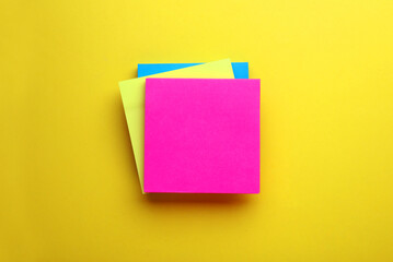 Paper notes on yellow background, top view