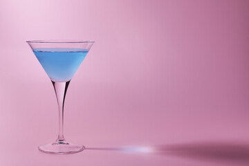 Martini glass with delicious cocktail on pink background, space for text