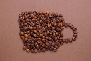 Cup of drink, composition made with coffee beans on brown background, flat lay