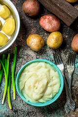 Mashed potatoes in a bowl with green onions .