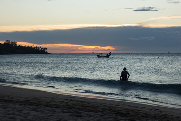 Homem procurando objetos na Praia do Curral - ILHABELA, SP, BRAZIL - DECEMBER 01, 2022: Man in backlight with metal detector looking for lost valuables at Praia do Curral (Curral beach).